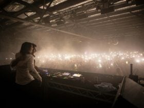 Large dance floor with hundreds of torches waving to the DJs