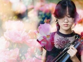 Young female violinist pictured in front of floral background