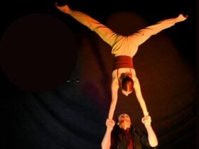 A young woman flies a hand to hand acrobatic form on a young male base