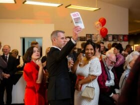 Guests holding their arms up with bidding sheets during a live auction