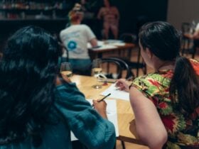 People facing away from the camera with pencils and paper