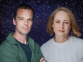 a male and female look directly at the camera. a background of starry night sky