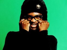 Genesis Owusu with hands on his cheeks smiling