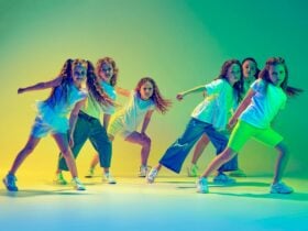 Image of young girls dancing with coloured lighting in background