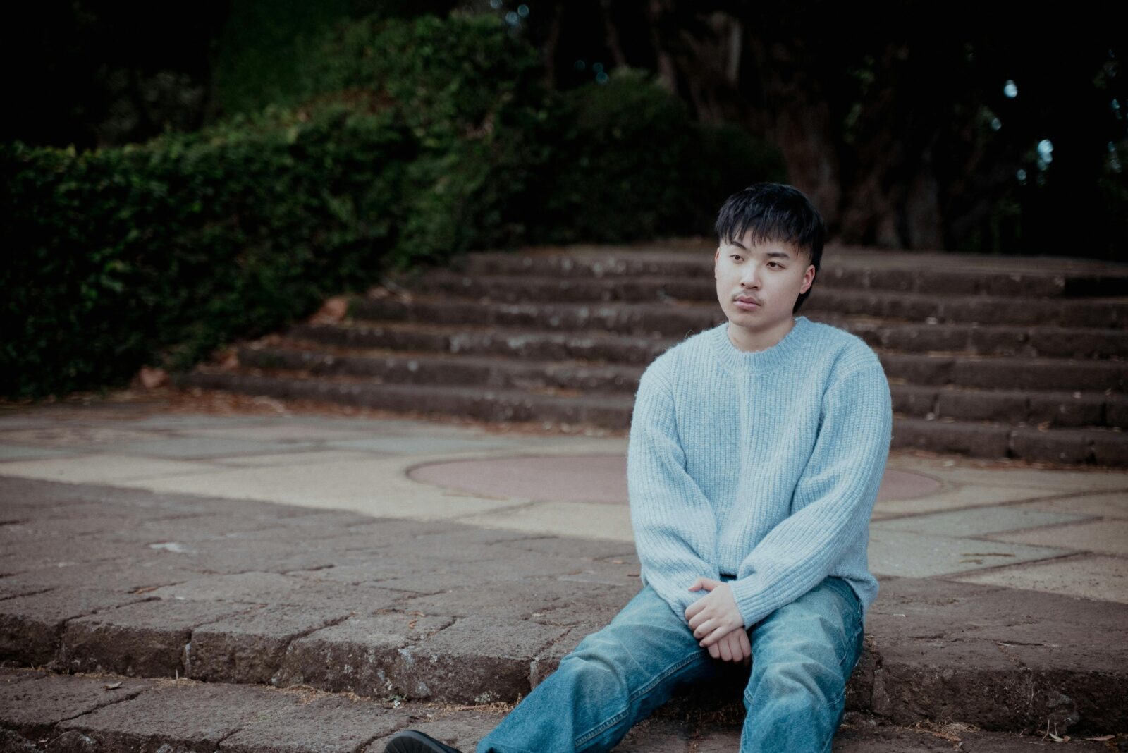 Keenan Te sitting on concrete looking off in the distance