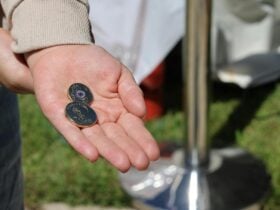 a hand holding 2 traded coins at the Mint