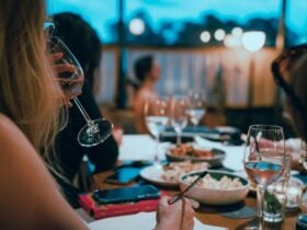 Woman drinking sparkling wine with art model sitting in background