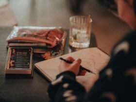 Person sketching with pastels and pencil case next to them