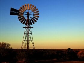 A tall windmill set in a twilight landscape