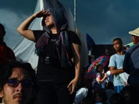 An image of multiple people in a crowd looking around in different directions