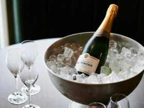 an image of a bottle of champagne in ice with glasses