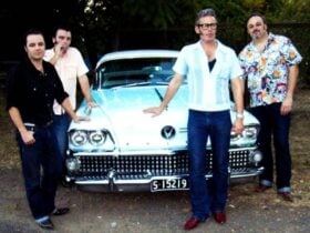 Photo of group of four men around 1950s classic car.