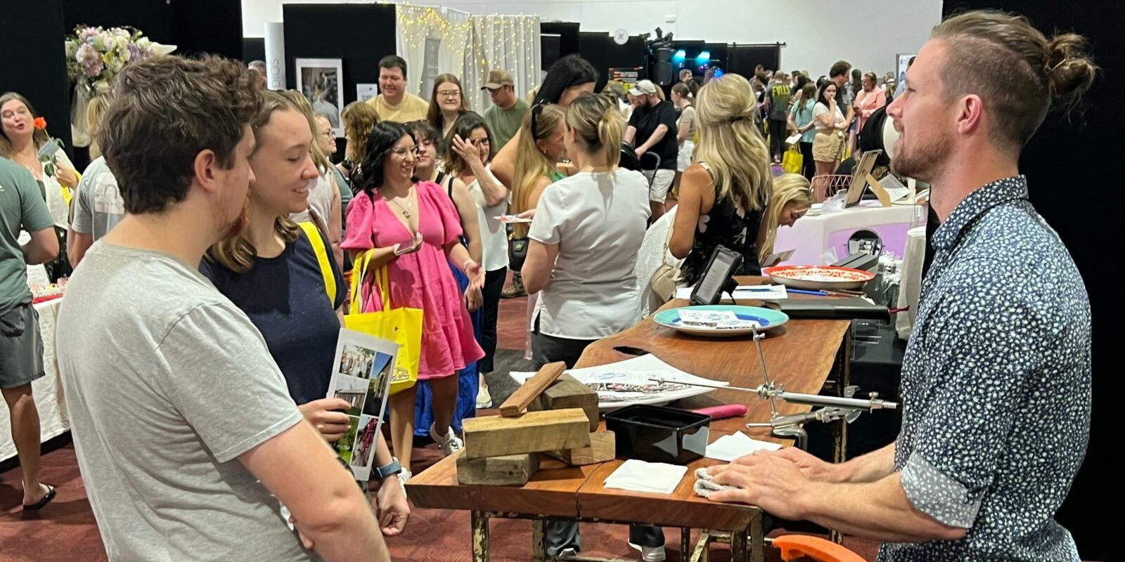 Couples talking with exhibitors at Your Local Wedding Guide Canberra Expo.