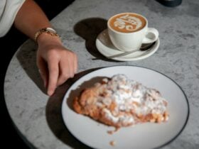 Cup of coffee and plate of pastry on table