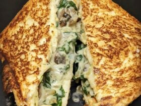Toasted sandwich cut in half with filling oozing out
