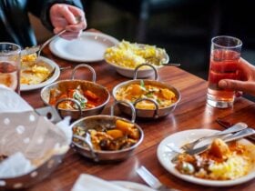 Dining table with a variety of food dishes in front of diners