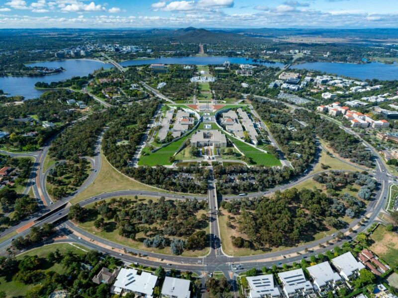 An aerial view shows the capital city with its buildings, streets, and surrounding landscape