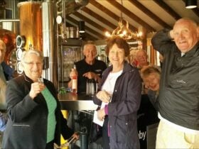 Six people in front of schnapps bar inside distillery