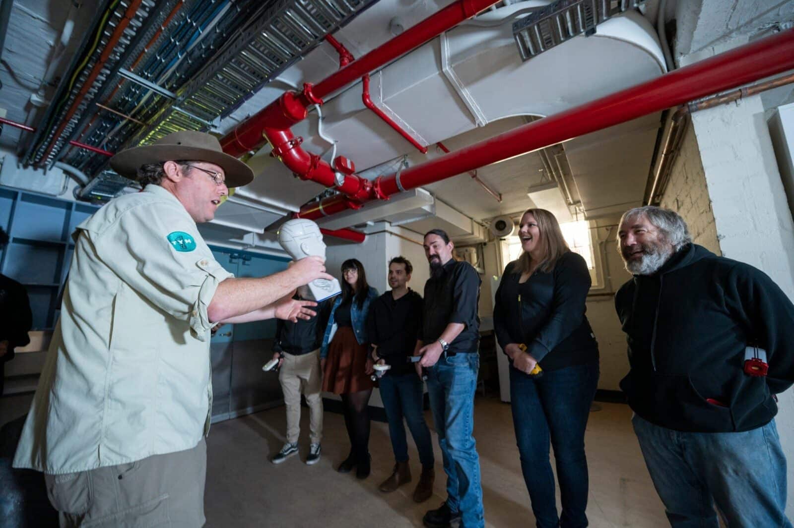 Man in khaki clothing talking to a group of people