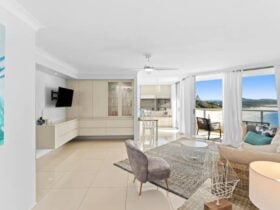 Living room with lounges, ceiling fan, TV and ocean views