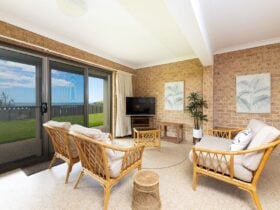 Second living room with rattan lounges, TV, ocean views