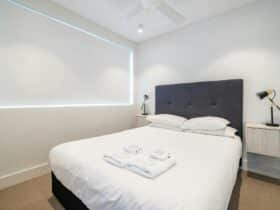 Modern bedroom with queen-sized bed and stylish furnishings in Bondi Beach apartment.