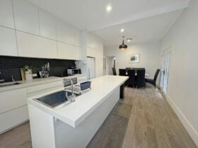 A modern kitchen with a large island and dining area.