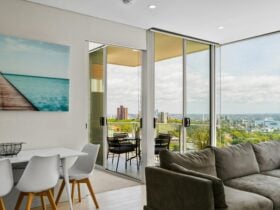 Modern living room with city skyline views and a balcony for outdoor seating.