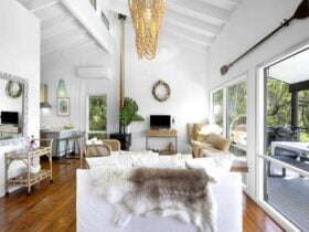 Open-plan living spaces flowing to a covered deck with a barbecue