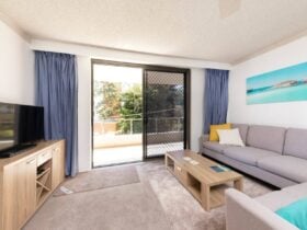 Lounge room with spacious lounge and TV