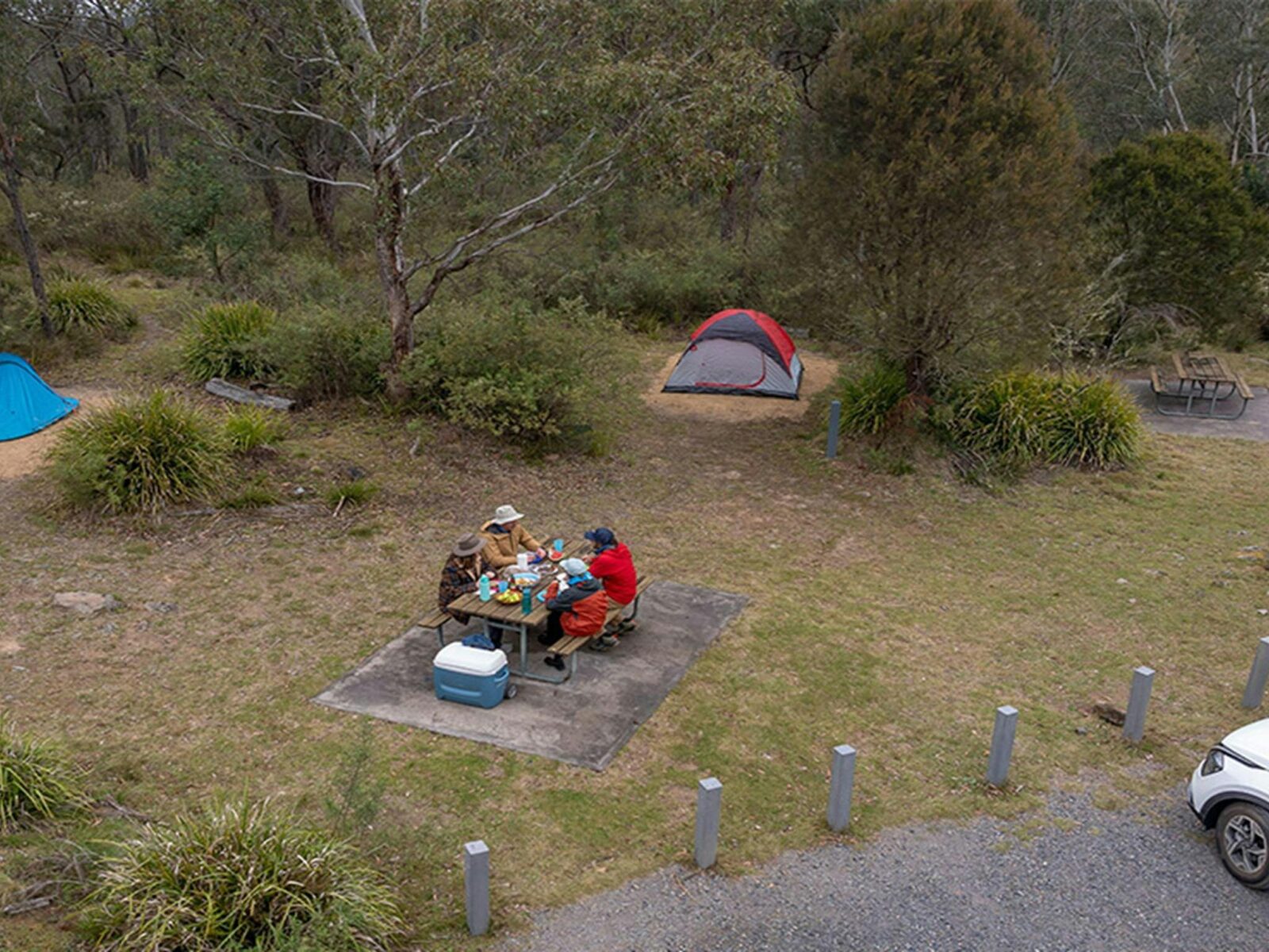 A group of campers eating at the picnic table next to their campsite at Bungonia campground. Photo: