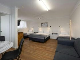 Full room view including beds, dining table, lounge and bathroom