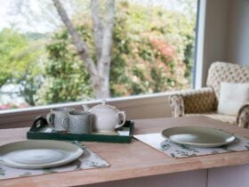 Breakfast bar with crockery setting looking through window to trees