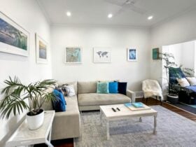 Cozy living room with a comfy sofa, colorful pillows, and framed artwork on the wall.