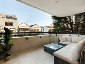 Outdoor balcony with comfy seating and a view of the neighborhood.