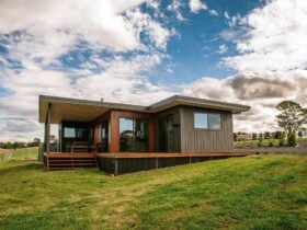 Photo of Dorrigo Rainforest Retreat cottage with blue sky, clouds and green farmland