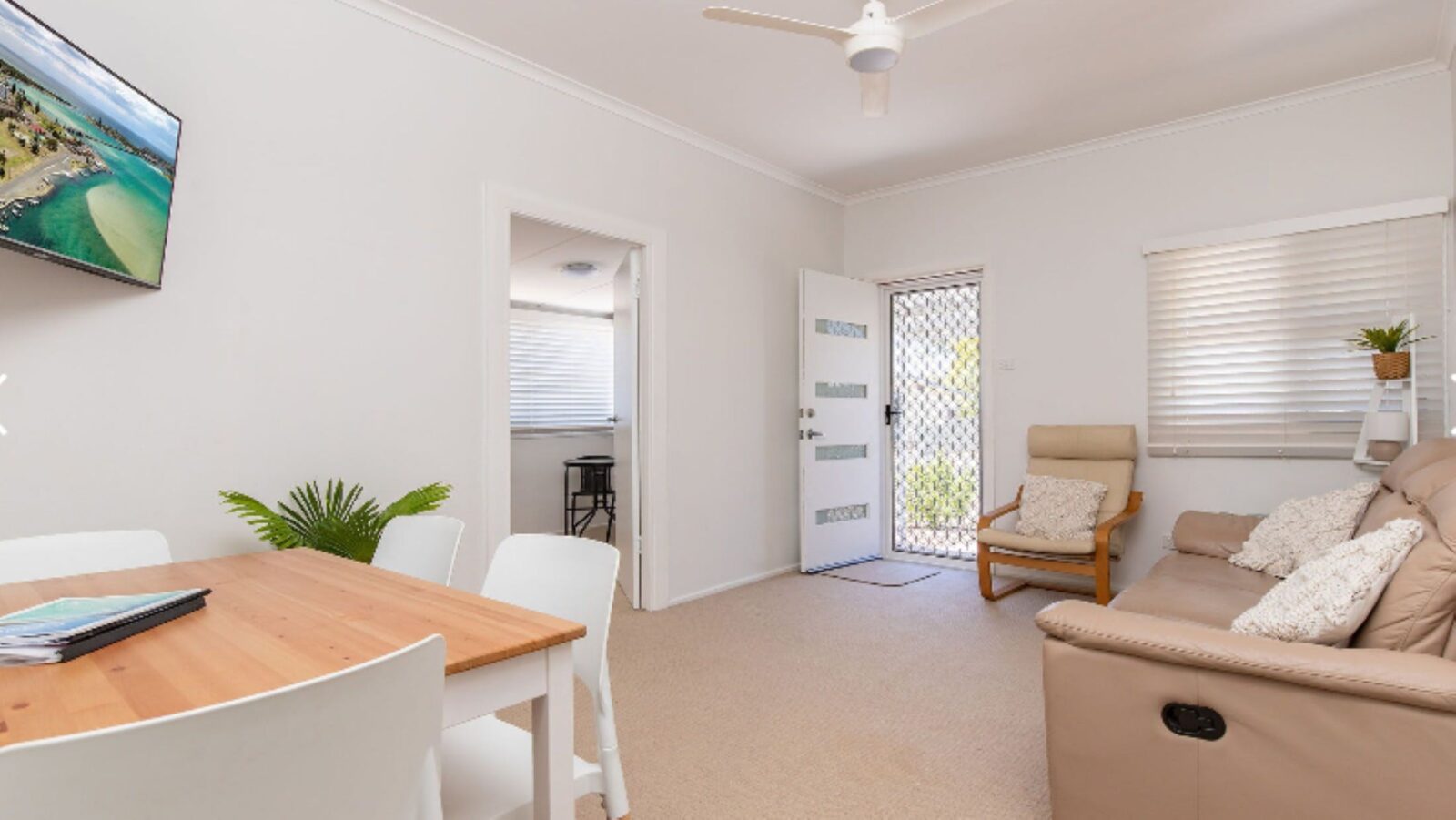 Living and dining room with TV, lounge and 4 seater dining setting