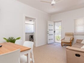 Living and dining room with TV, lounge and 4 seater dining setting