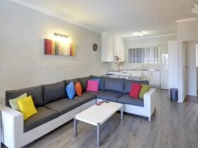 Living area with spacious lounge, kitchen with breakfast bar and stools