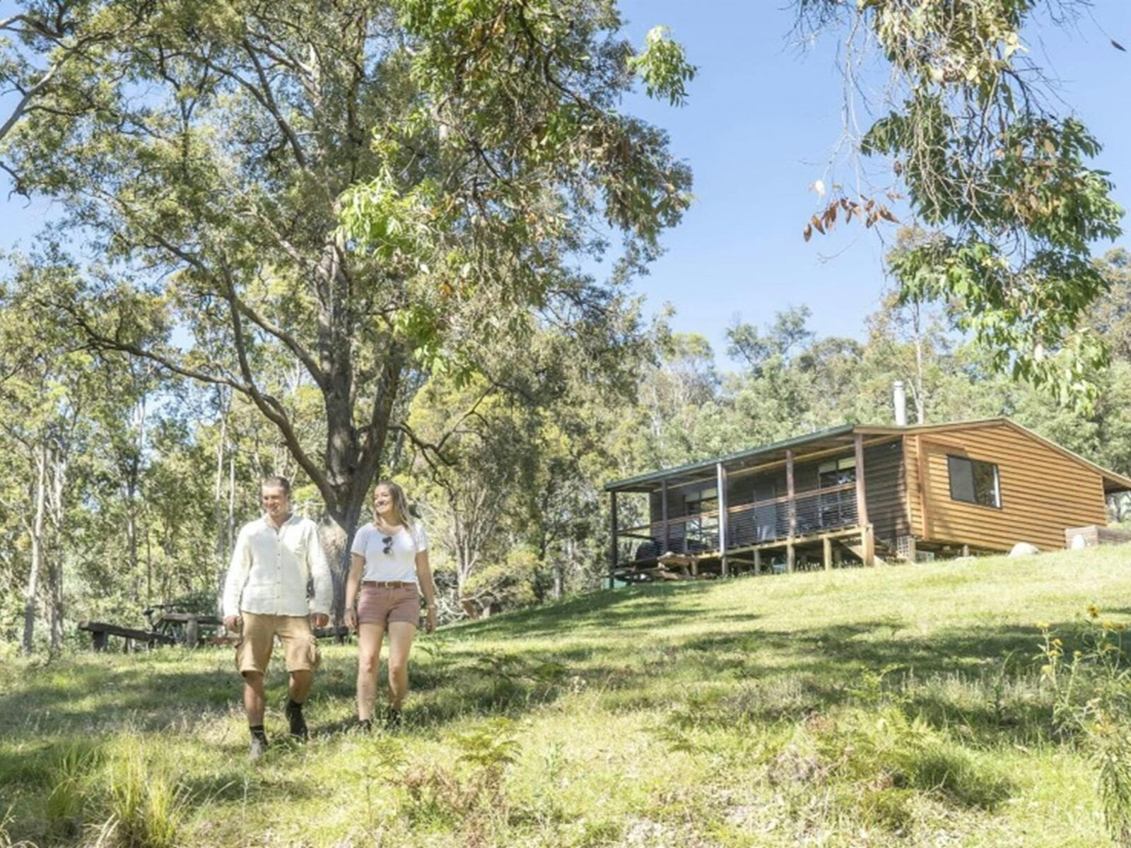 A couple walking down the hill outside Galong cabins in the Southern Blue Mountains area of Blue