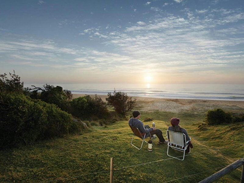 A couple watching the sunrise at Gillards campground, Mimosa Rocks National Park. Photo: David