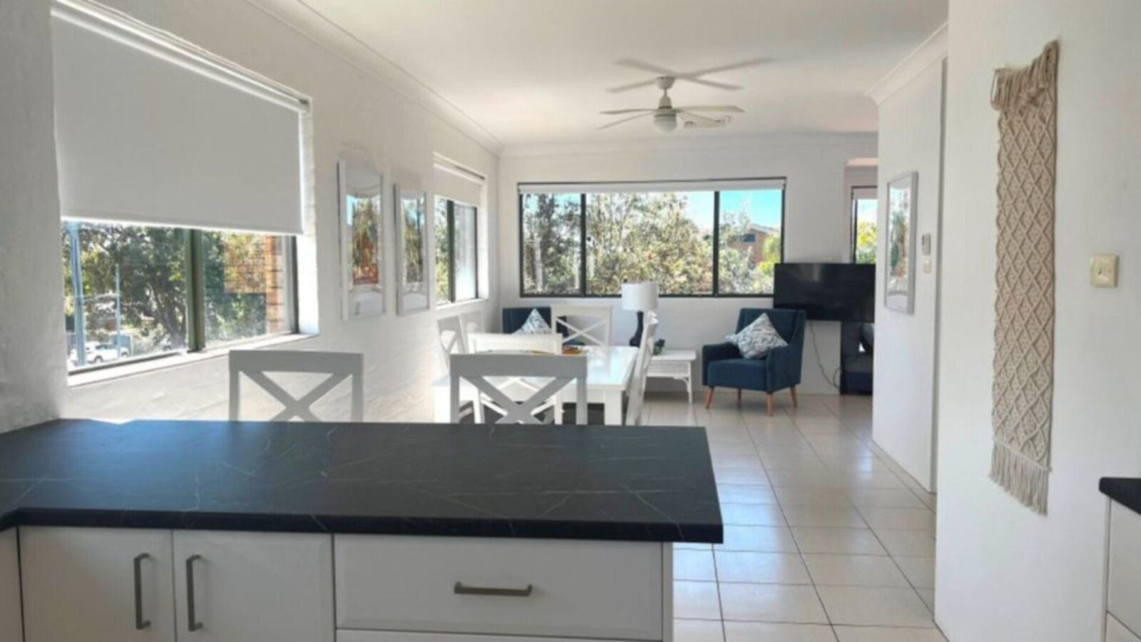 Breakfast bar with stools, dining/lounge room in background
