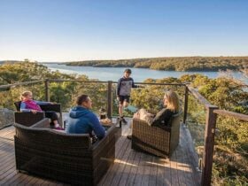 A family enjoying the view from the balcony of Hilltop Cottage in Royal National Park. Photo: John
