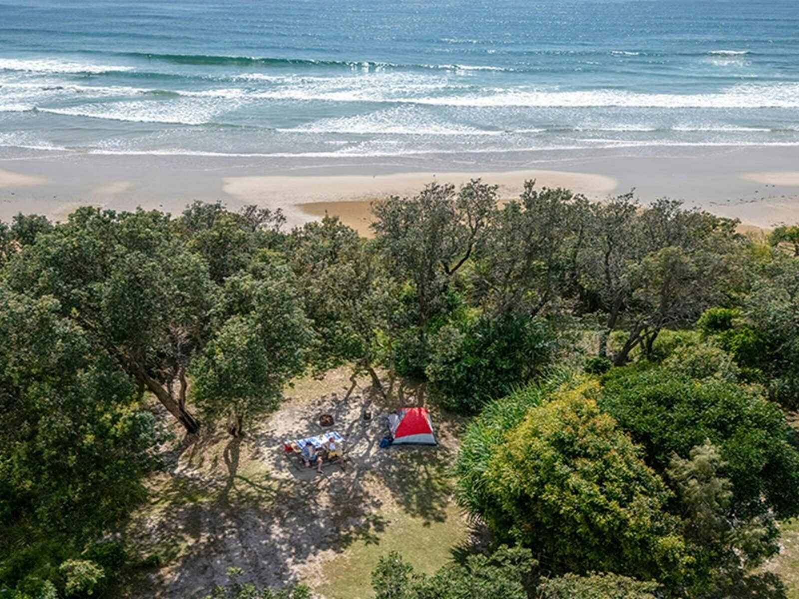 Aerial view of a tent campsite set back from the ocean at Illaroo campground. Credit: John Spencer