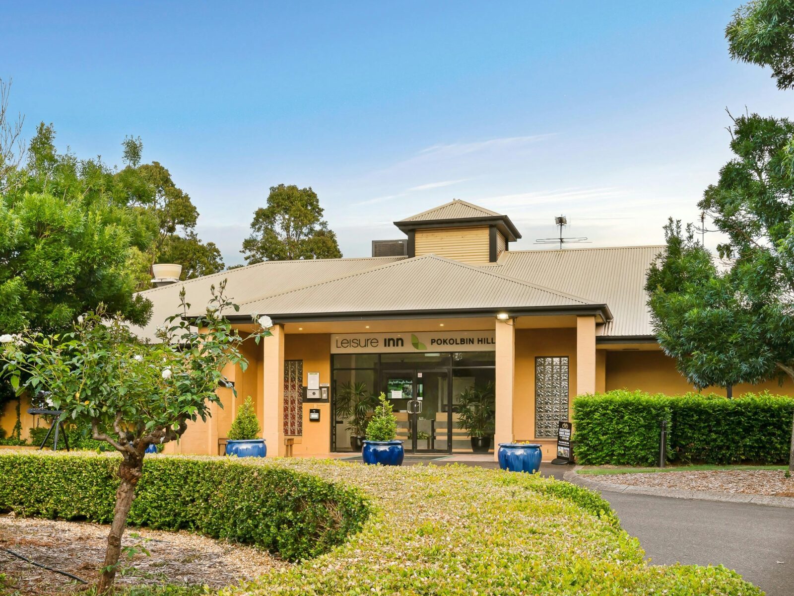 Entrance of Leisure Inn Pokolbin Hill with signage and landscaped gardens