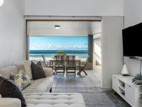 living room overlooking outdoor patio with ocean views