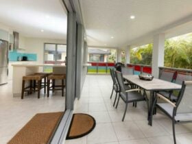 Balcony with dining setting surrounded by palm trees