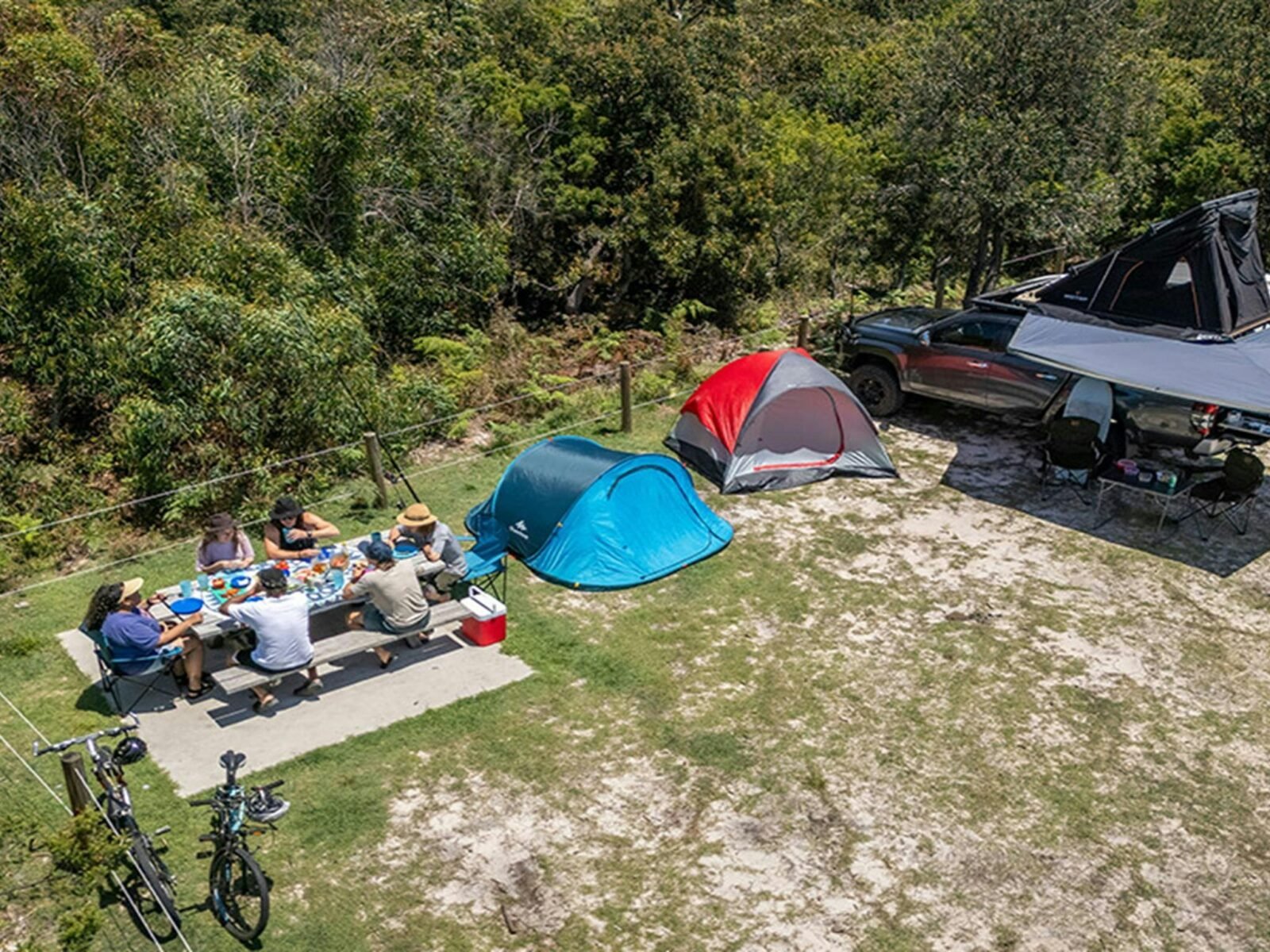 A group of campers eating at the picnic table on their campsite at Mibanbah-Black Rocks campground.