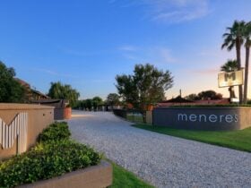 Motel Meneres front entrance at dusk showing rushed rock driveway with rendered brick entry.