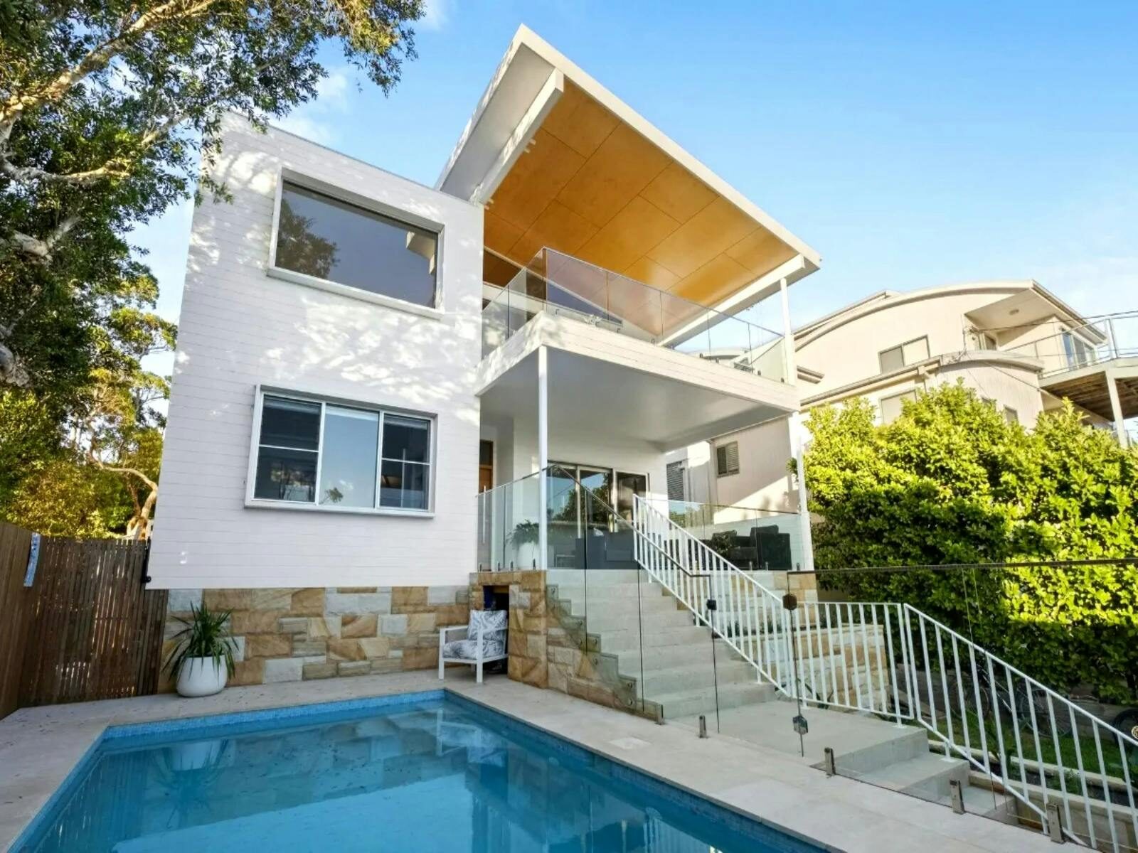 Private terraces, expansive decks, sun-drenched patios, and inviting saltwater pool adorn the home